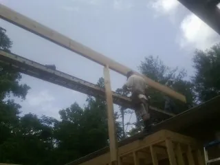 Carpenter setting a ridge beam over a new addition frame — Ice Dam Removal by Roofing Brothers in Cypress