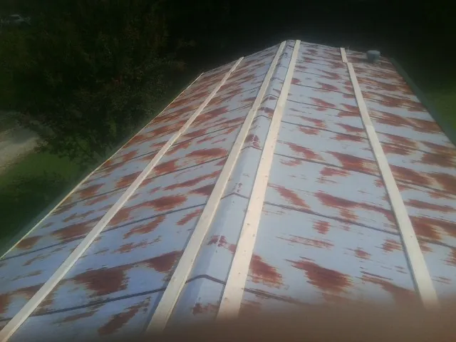 Rusted metal roof panels with new wood purlins before replacement — Storm Damage Roof Repair in Cypress by Roofing Brothers